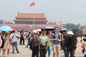 A Chinese soldier stands guard on a bustling day in Tiananmen Square. 